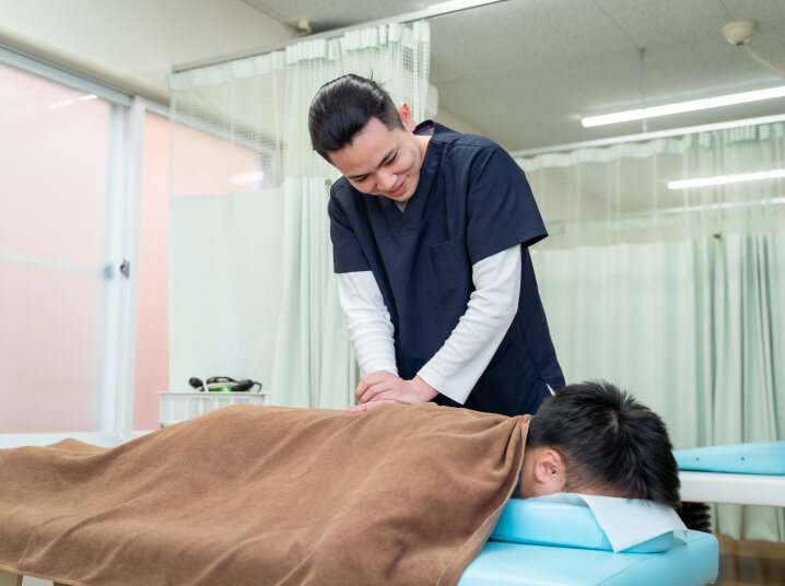 施術台で施術をしているスタッフ